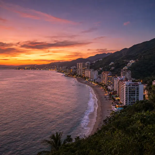 Banderas Bay at dusk, the curving coastline and high rises lit under an orange sky.